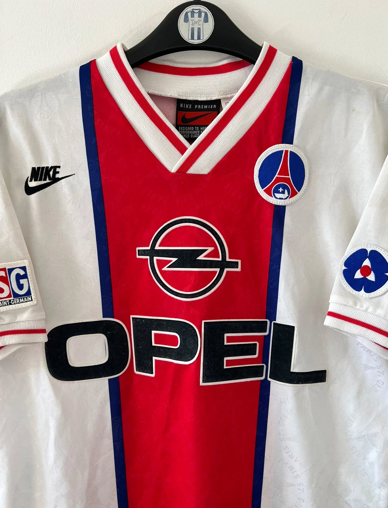 Maillot de foot vintage extérieur blanc et rouge du PSG 1995/1996. On peut retrouver l'équipementier Nike et le sponsor Opel. Le maillot est floqué du numéro 7 Leonardo. Il s'agit d'un maillot authentique d'époque. 