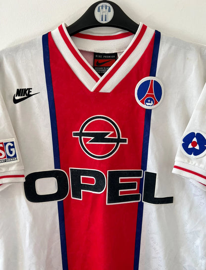 Maillot de foot vintage extérieur blanc et rouge du PSG 1995/1996. On peut retrouver l'équipementier Nike et le sponsor Opel. Le maillot est floqué du numéro 7 Leonardo. Il s'agit d'un maillot authentique d'époque. 