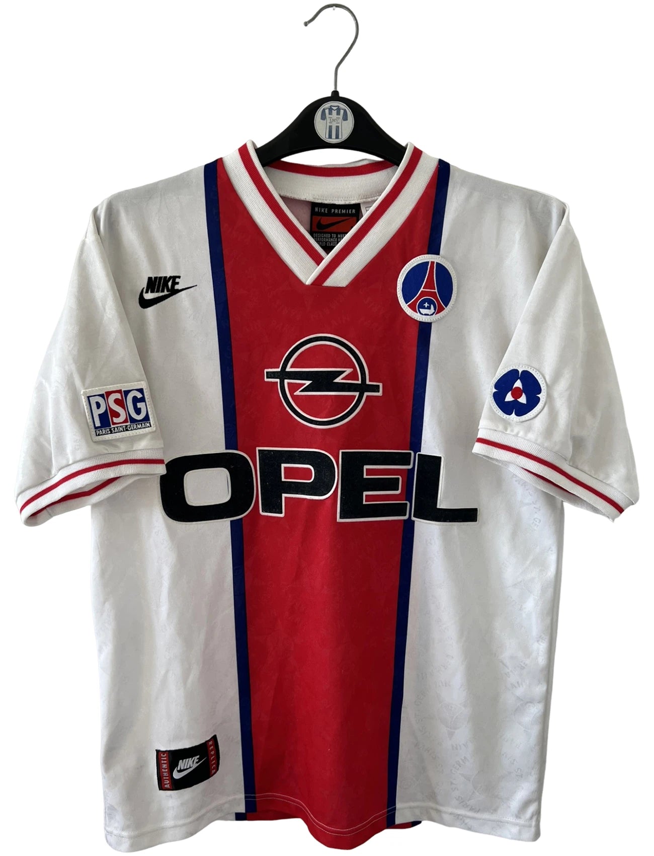 Maillot de foot vintage extérieur blanc et rouge du PSG 1995/1996. On peut retrouver l'équipementier Nike et le sponsor Opel. Le maillot est floqué du numéro 7 Leonardo. Il s'agit d'un maillot authentique d'époque. 