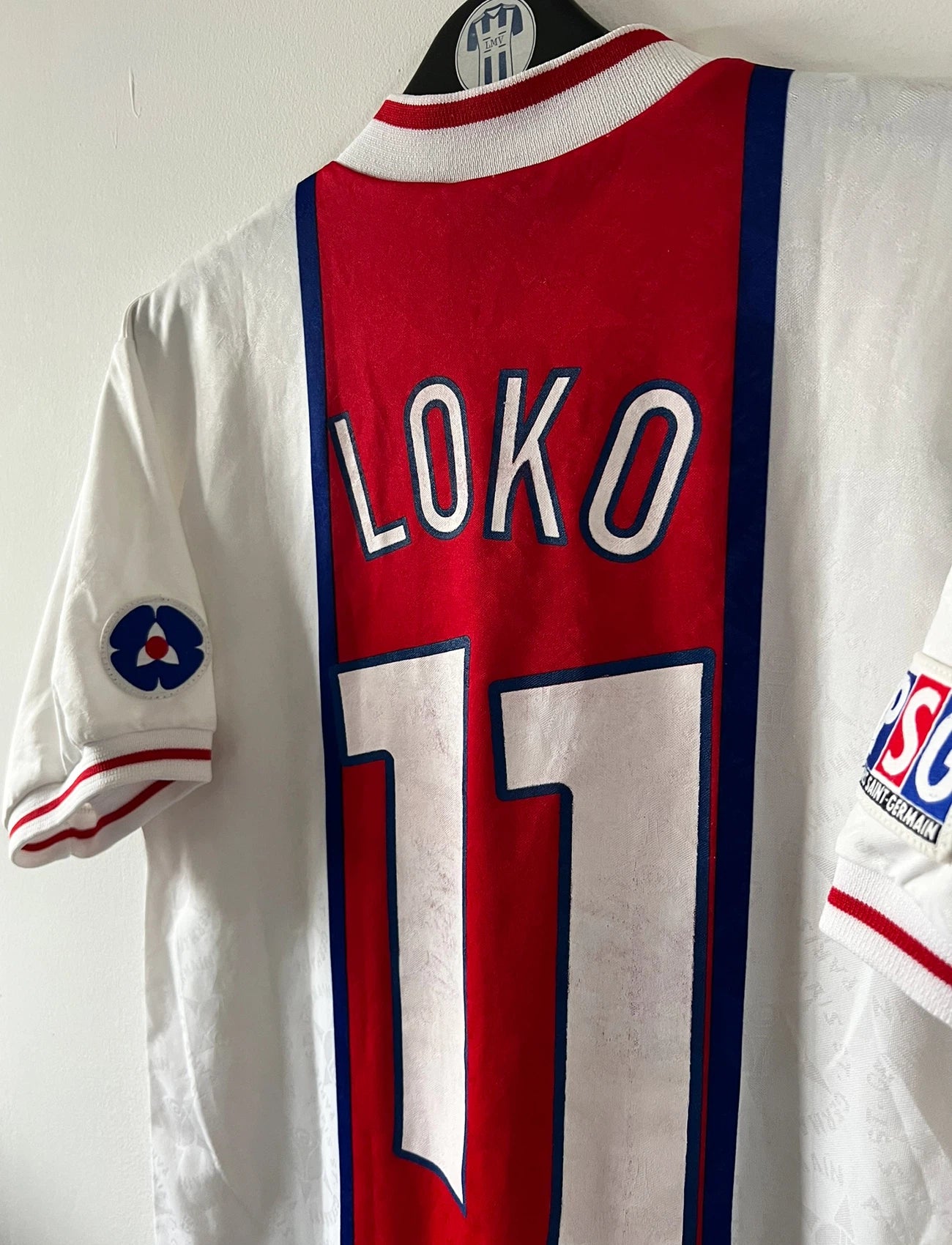 Maillot de foot vintage extérieur blanc du PSG de la saison 1995/1996. On peut retrouver l'équipementier Nike et le sponsor Opel. Le maillot est floqué du numéro 11 Patrice Loko. Il s'agit d'un maillot authentique d'époque.