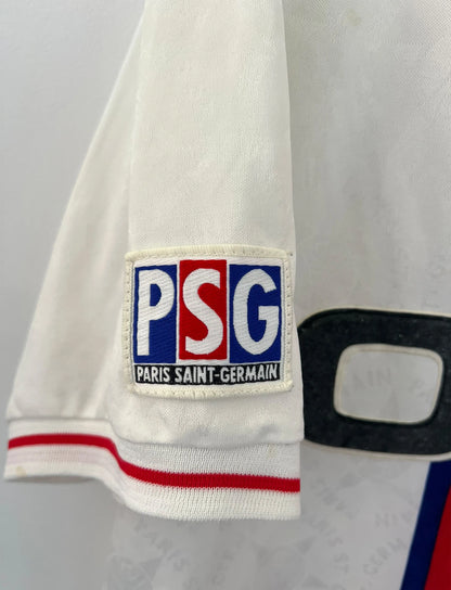 Maillot de foot vintage extérieur blanc du PSG de la saison 1995/1996. On peut retrouver l'équipementier Nike et le sponsor Opel. Il s'agit d'un maillot authentique d'époque.