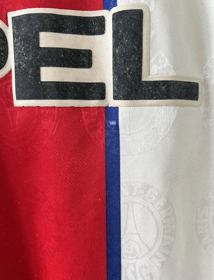 Maillot de foot vintage blanc rouge et bleu du PSG de la saison 1996/1997. On peut retrouver l'équipementier nike et le sponsor opel. Il s'agit d'un maillot authentique d'époque.