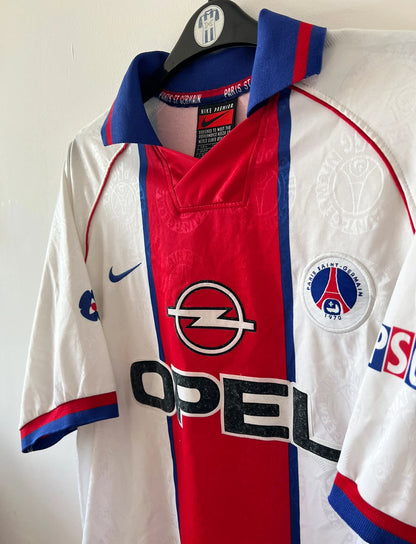 Maillot de foot vintage extérieur blanc du PSG 1996/1997. On peut retrouver l'équipementier Nike et le sponsor Opel. Il s'agit d'un maillot authentique d'époque.