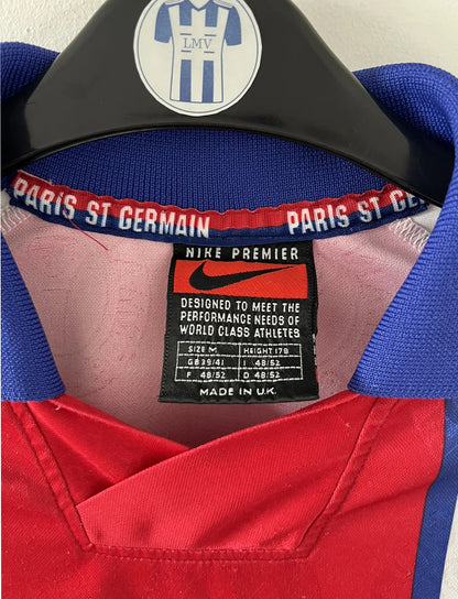 Maillot de foot vintage blanc rouge et bleu du PSG de la saison 1996/1997. On peut retrouver l'équipementier nike et le sponsor opel. Il s'agit d'un maillot authentique d'époque.