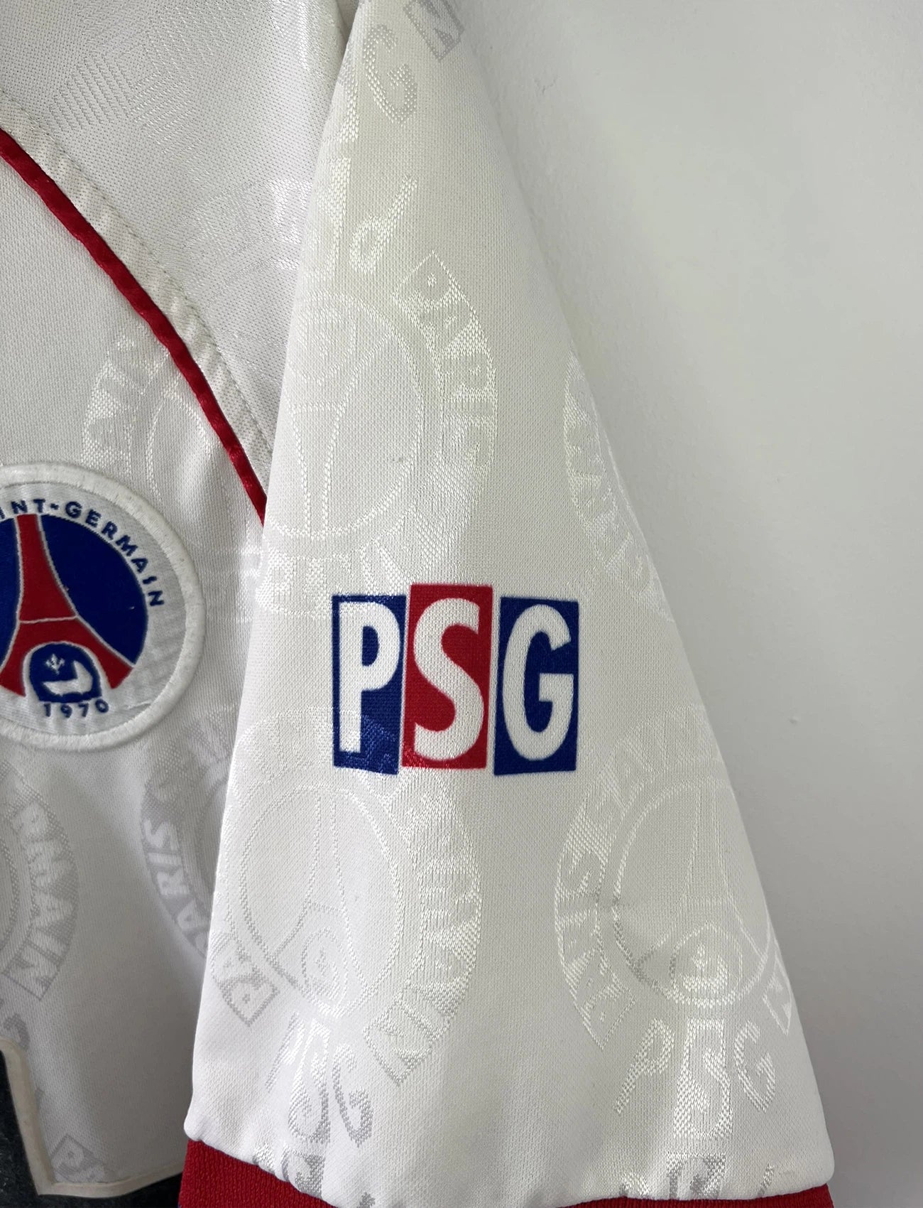 Maillot de foot vintage blanc rouge et bleu du PSG de la saison 1996/1997. On peut retrouver l'équipementier nike et le sponsor opel. Il s'agit d'un maillot authentique d'époque.