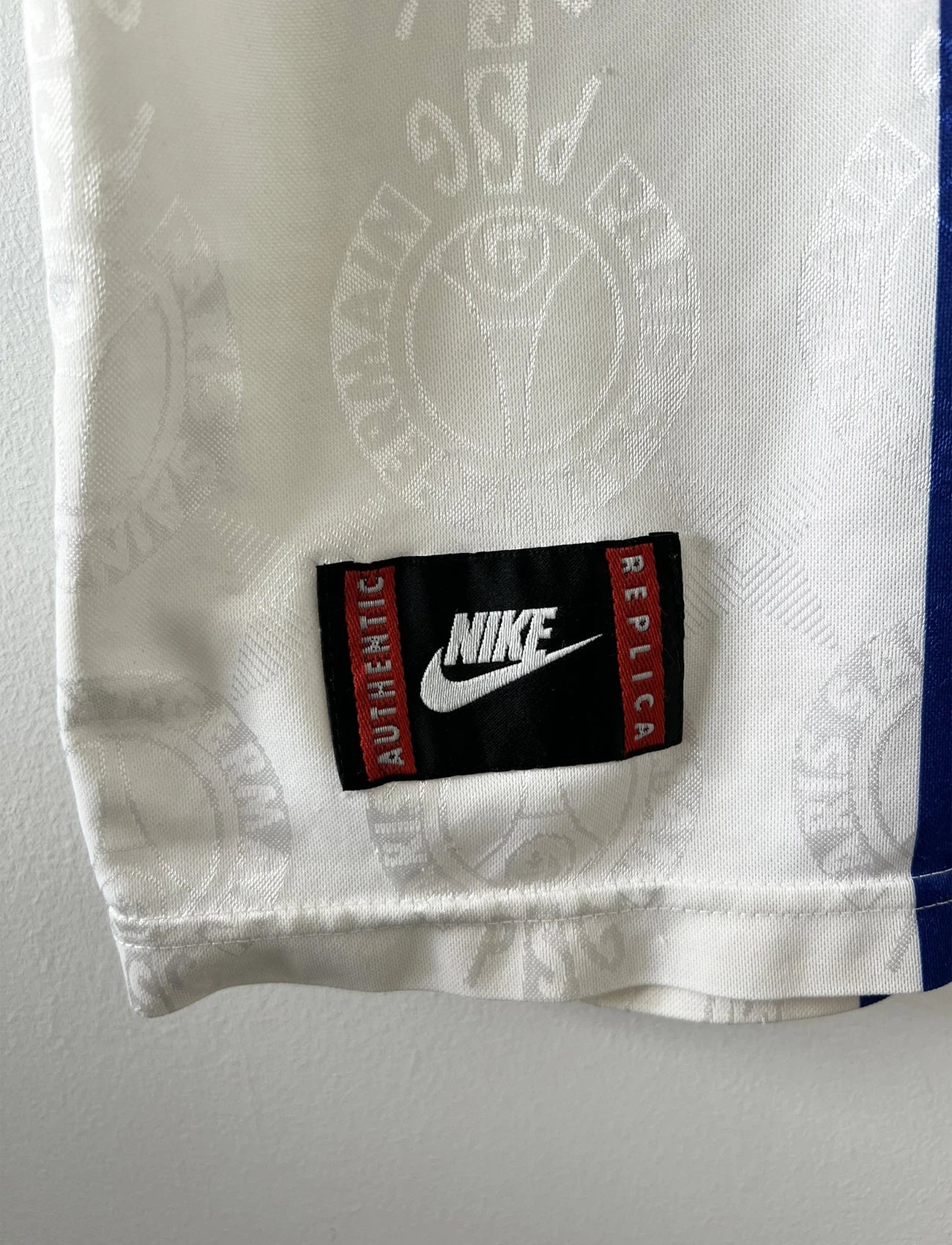 Maillot de foot vintage blanc rouge et bleu du PSG de la saison 1996/1997. On peut retrouver l'équipementier nike et le sponsor opel. Il s'agit d'un maillot authentique d'époque.