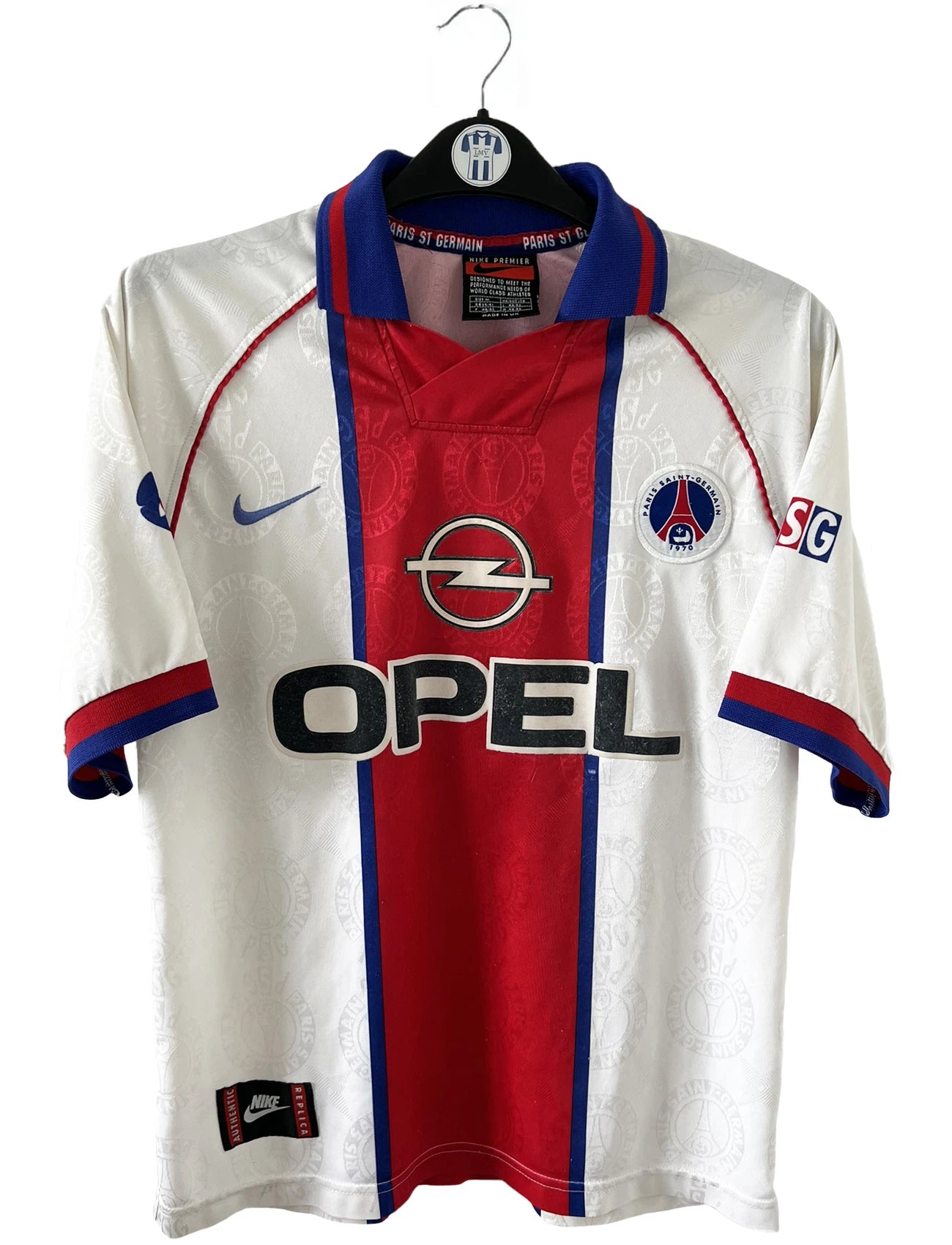 Maillot de foot vintage blanc rouge et bleu du PSG de la saison 1996/1997. On peut retrouver l'équipementier nike et le sponsor opel. Il s'agit d'un maillot authentique d'époque.