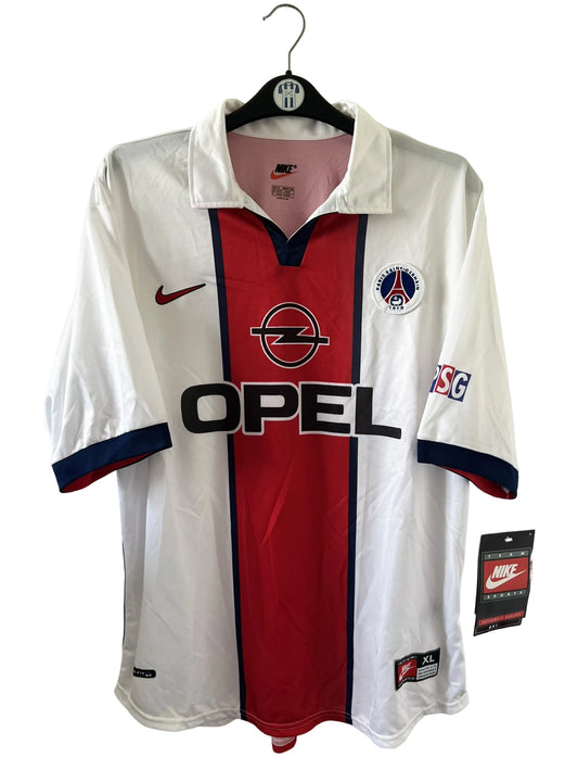 Maillot extérieur PSG blanc et rouge de la saison 1998/1999. On peut retrouver l'équipementier Nike et le sponsor Opel. Il s'agit d'un maillot authentique d'époque.