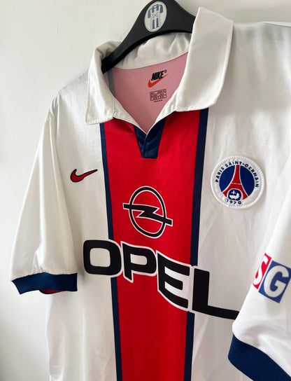 Maillot de foot vintage extérieur blanc du PSG de la saison 1998/1999. On peut retrouver l'équipementier Nike et le sponsor Opel. Il s'agit d'un maillot authentique d'époque.