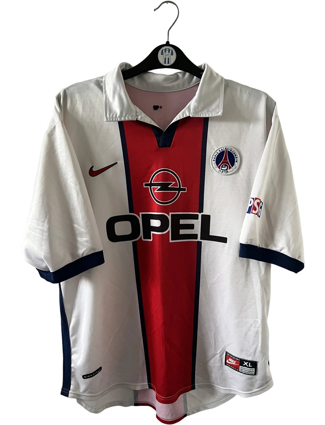Maillot extérieur PSG blanc et rouge de la saison 1998/1999. On peut retrouver l'équipementier Nike et le sponsor Opel. Il s'agit d'un maillot authentique d'époque.
