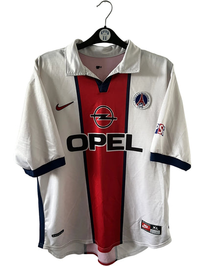 Maillot extérieur PSG blanc et rouge de la saison 1998/1999. On peut retrouver l'équipementier Nike et le sponsor Opel. Il s'agit d'un maillot authentique d'époque.