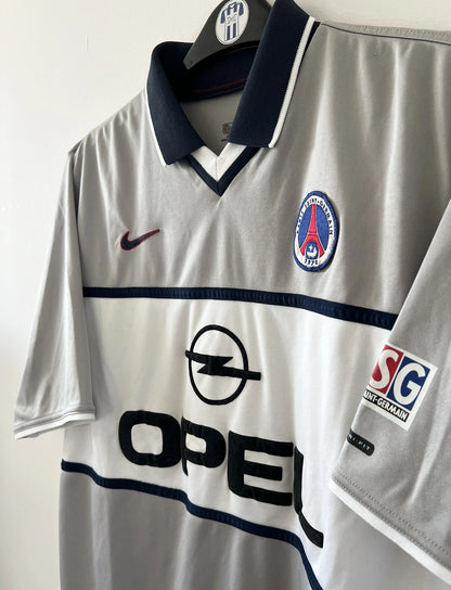 Maillot de foot vintage extérieur gris du PSG de la saison 2000/2001. On peut retrouver l'équipementier Nike et le sponsor Opel. Il s'agit d'un maillot authentique d'époque.