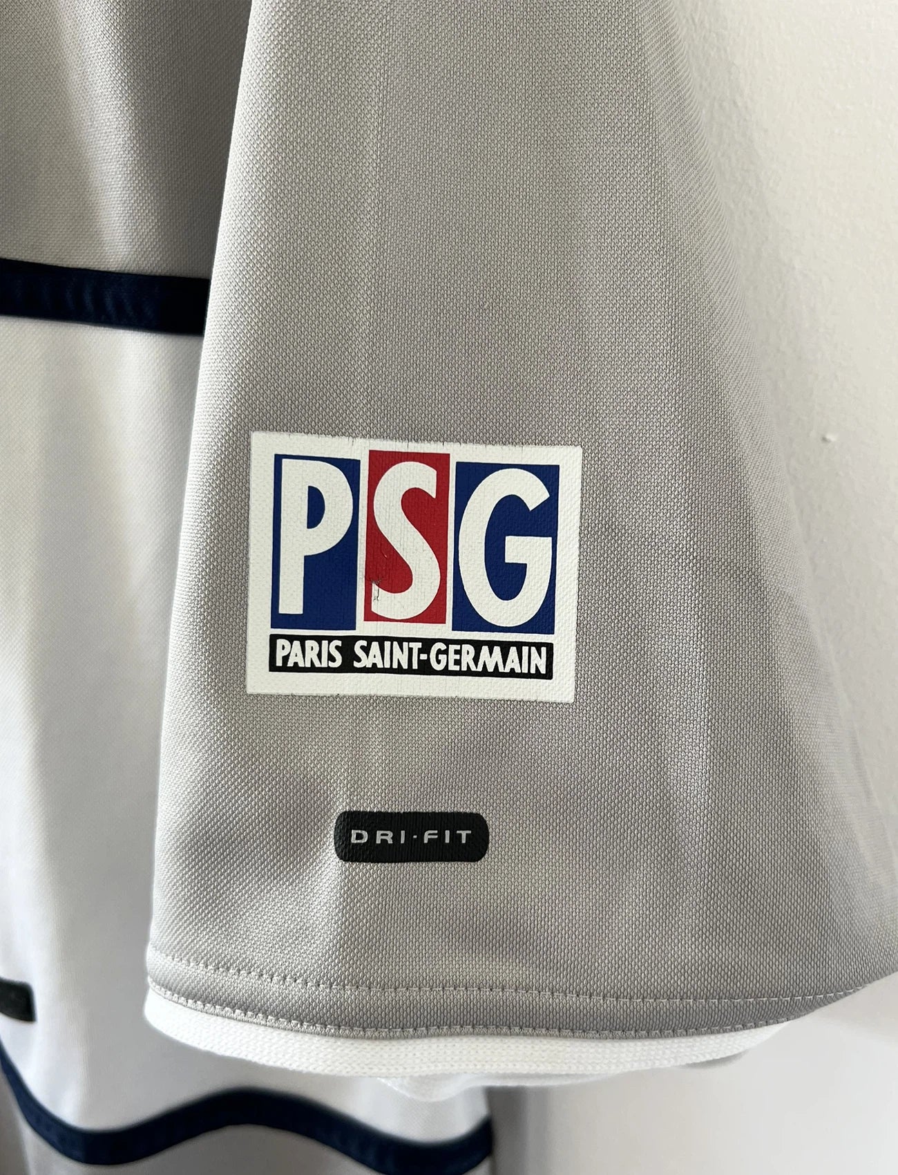Maillot de foot vintage extérieur gris du PSG de la saison 2000/2001. On peut retrouver l'équipementier Nike et le sponsor Opel. Il s'agit d'un maillot authentique d'époque.