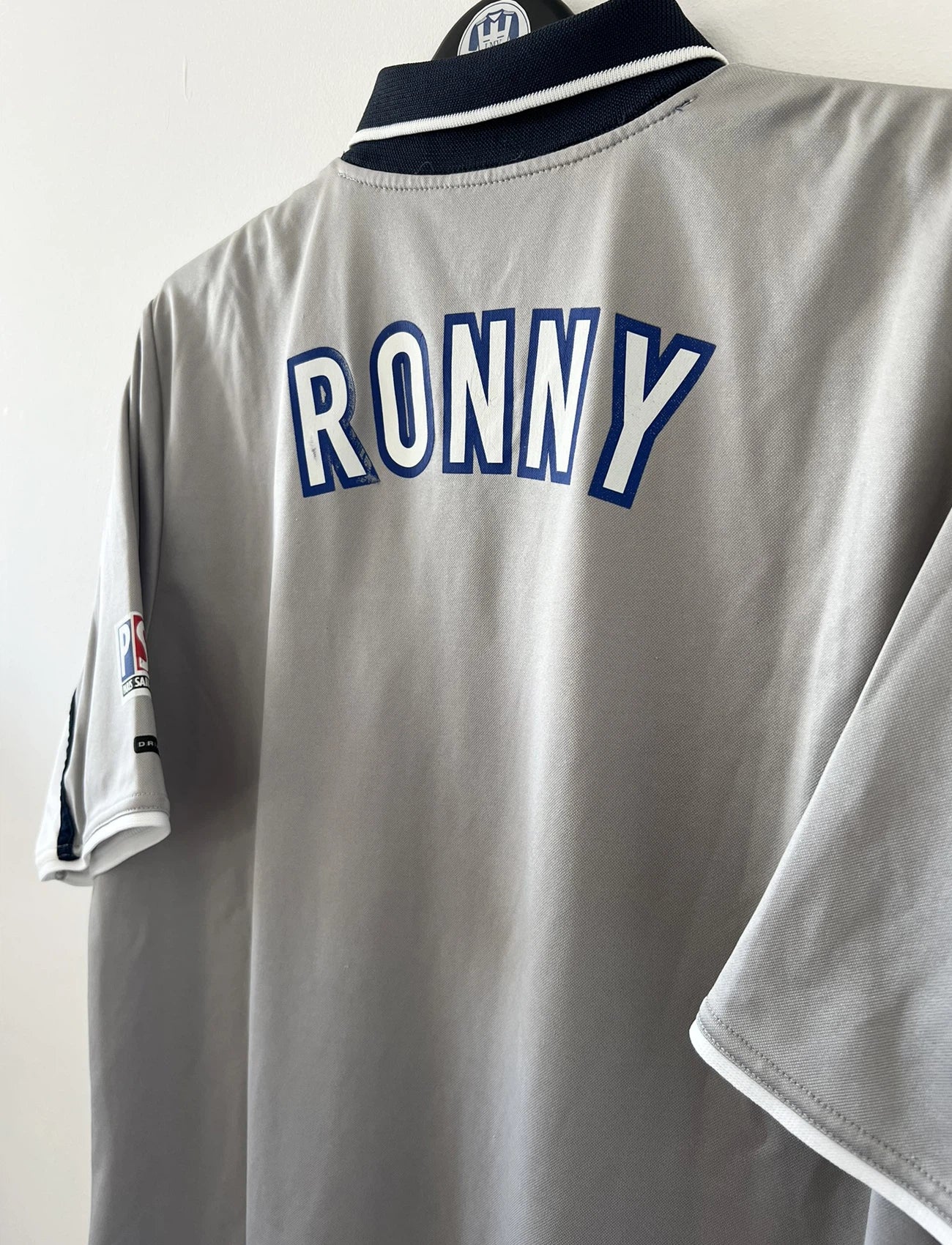 Maillot de foot vintage extérieur gris du PSG de la saison 2000/2001. On peut retrouver l'équipementier Nike et le sponsor Opel. Il s'agit d'un maillot authentique d'époque.