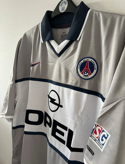 Maillot de foot vintage extérieur gris du PSG de la saison 2000/2001. On peut retrouver l'équipementier Nike et le sponsor Opel. Il s'agit d'un maillot authentique d'époque.