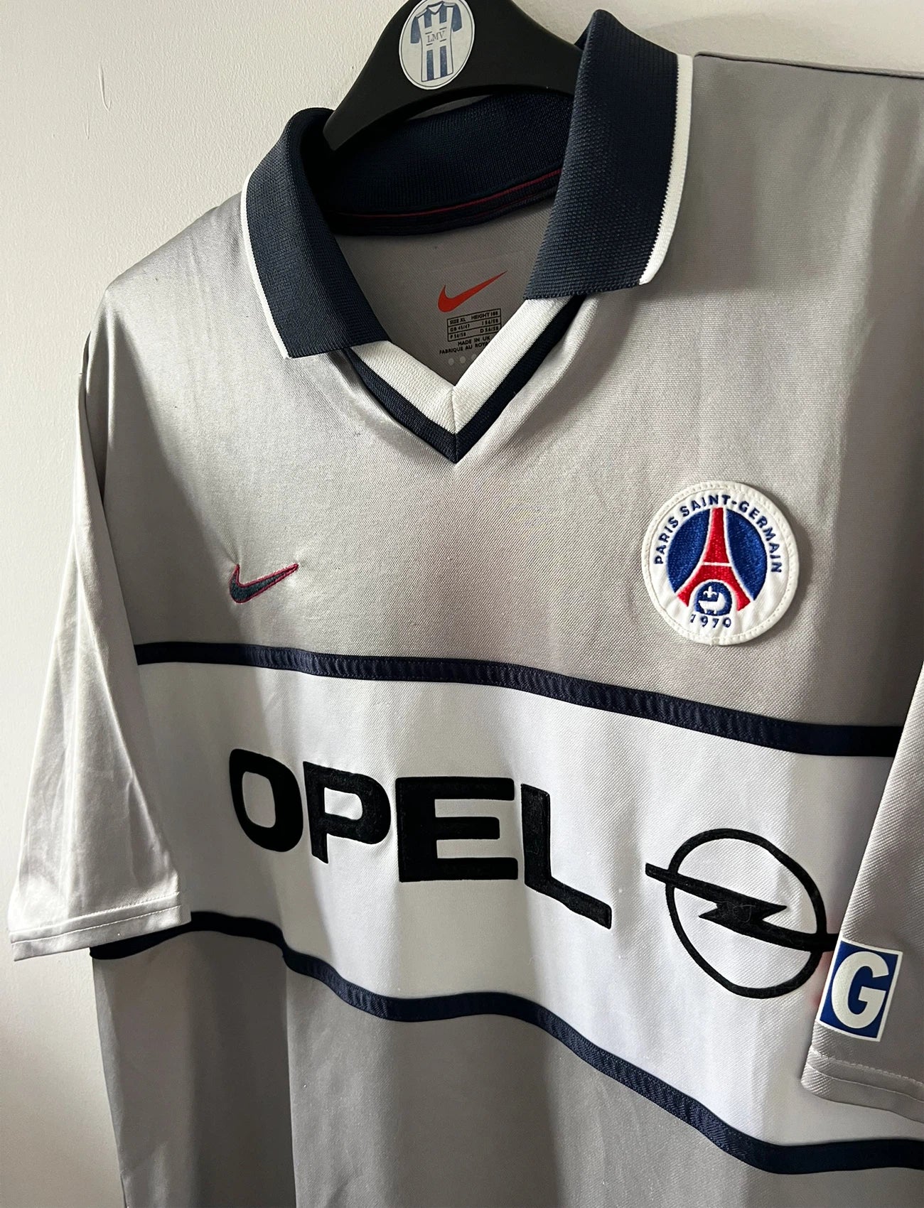 Maillot de foot vintage extérieur gris du PSG 2001/2002. On peut retrouver l'équipementier Nike et le sponsor Opel. Il s'agit d'un maillot authentique d'époque.