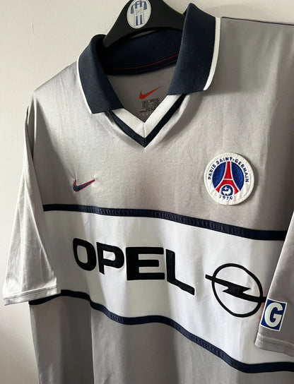 Maillot de foot vintage extérieur gris du PSG 2001/2002. On peut retrouver l'équipementier Nike et le sponsor Opel. Il s'agit d'un maillot authentique d'époque.