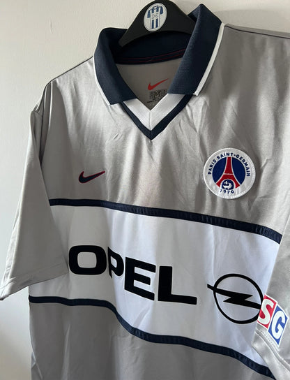 Maillot de foot vintage extérieur gris du PSG de la saison 2000/2001. On peut retrouver l'équipementier Nike et le sponsor Opel. Il s'agit d'un maillot authentique d'époque.