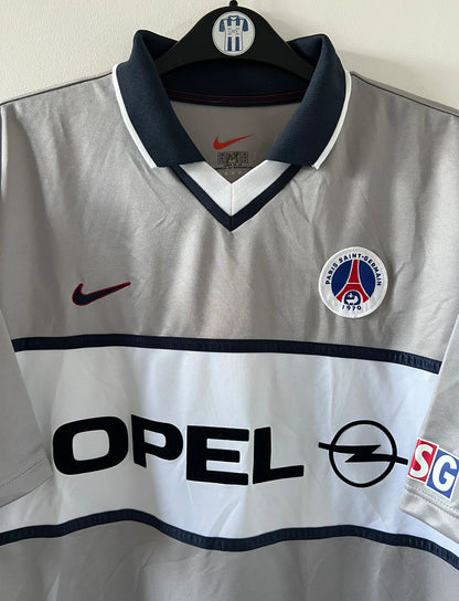 Maillot de foot vintage extérieur gris du PSG de la saison 2000/2001. On peut retrouver l'équipementier Nike et le sponsor Opel. Il s'agit d'un maillot authentique d'époque.