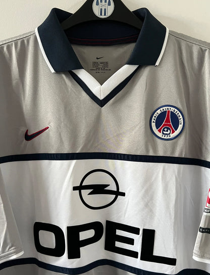 Maillot de foot vintage extérieur gris du PSG de la saison 2000/2001. On peut retrouver l'équipementier Nike et le sponsor Opel. Il s'agit d'un maillot authentique d'époque.