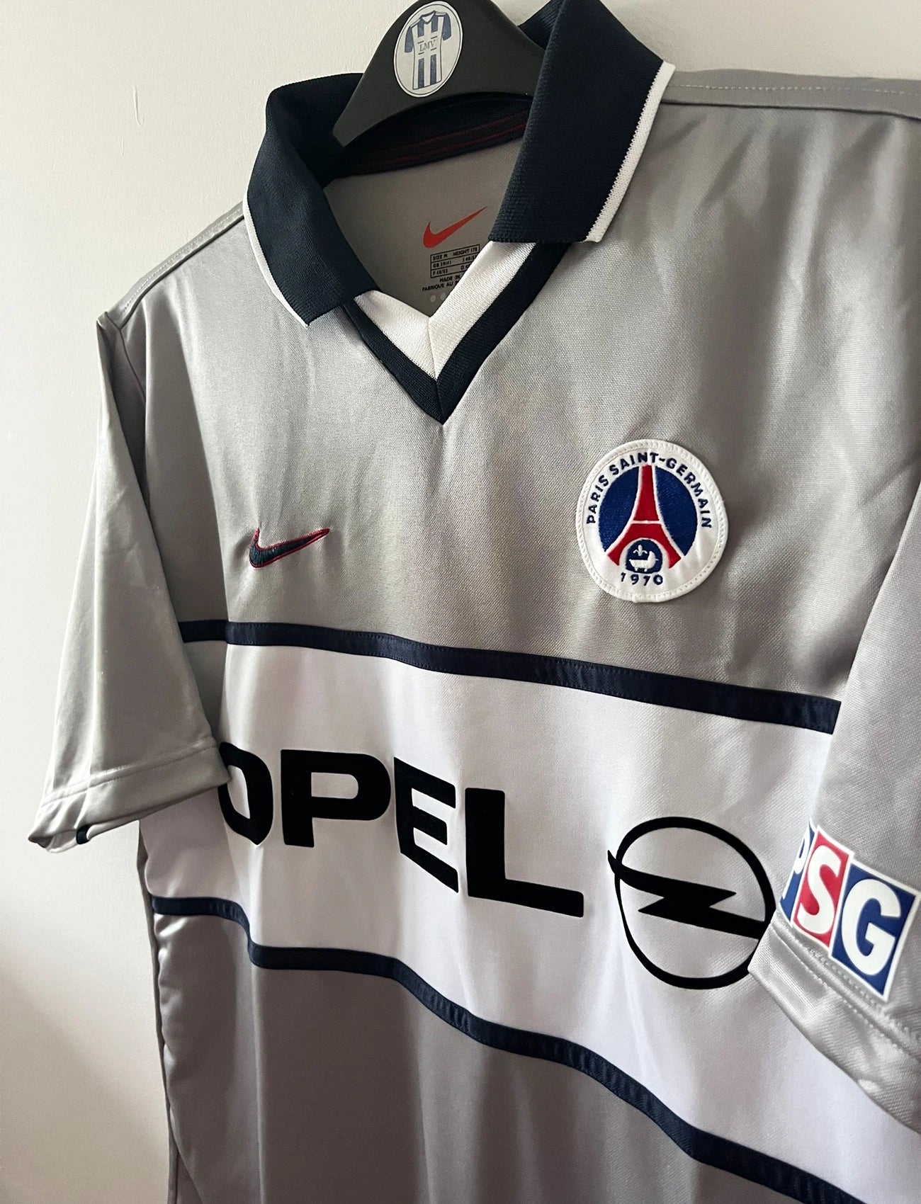 Maillot de foot vintage extérieur gris du PSG de la saison 2000/2001. On peut retrouver l'équipementier Nike et le sponsor Opel. Il s'agit d'un maillot authentique d'époque.