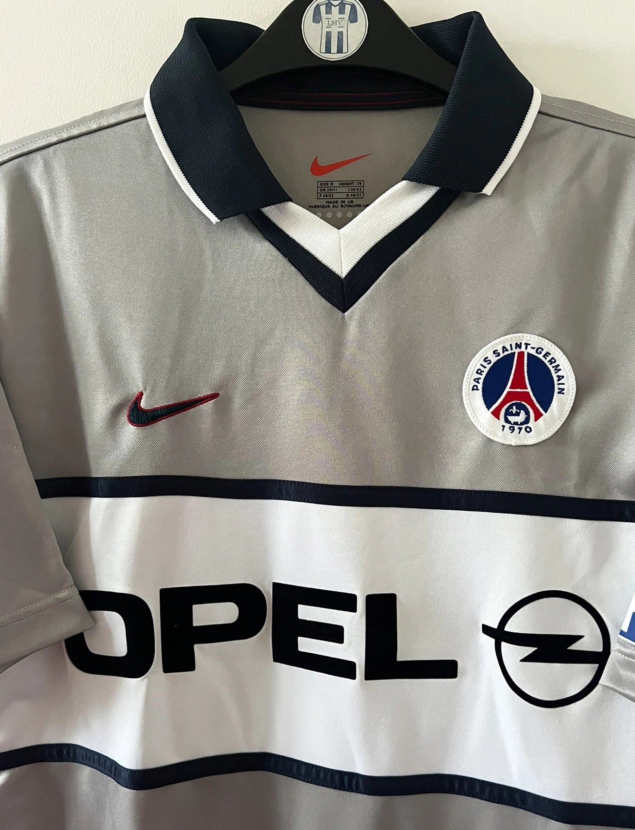 Maillot de foot vintage extérieur gris du PSG de la saison 2000/2001. On peut retrouver l'équipementier Nike et le sponsor Opel. Il s'agit d'un maillot authentique d'époque.