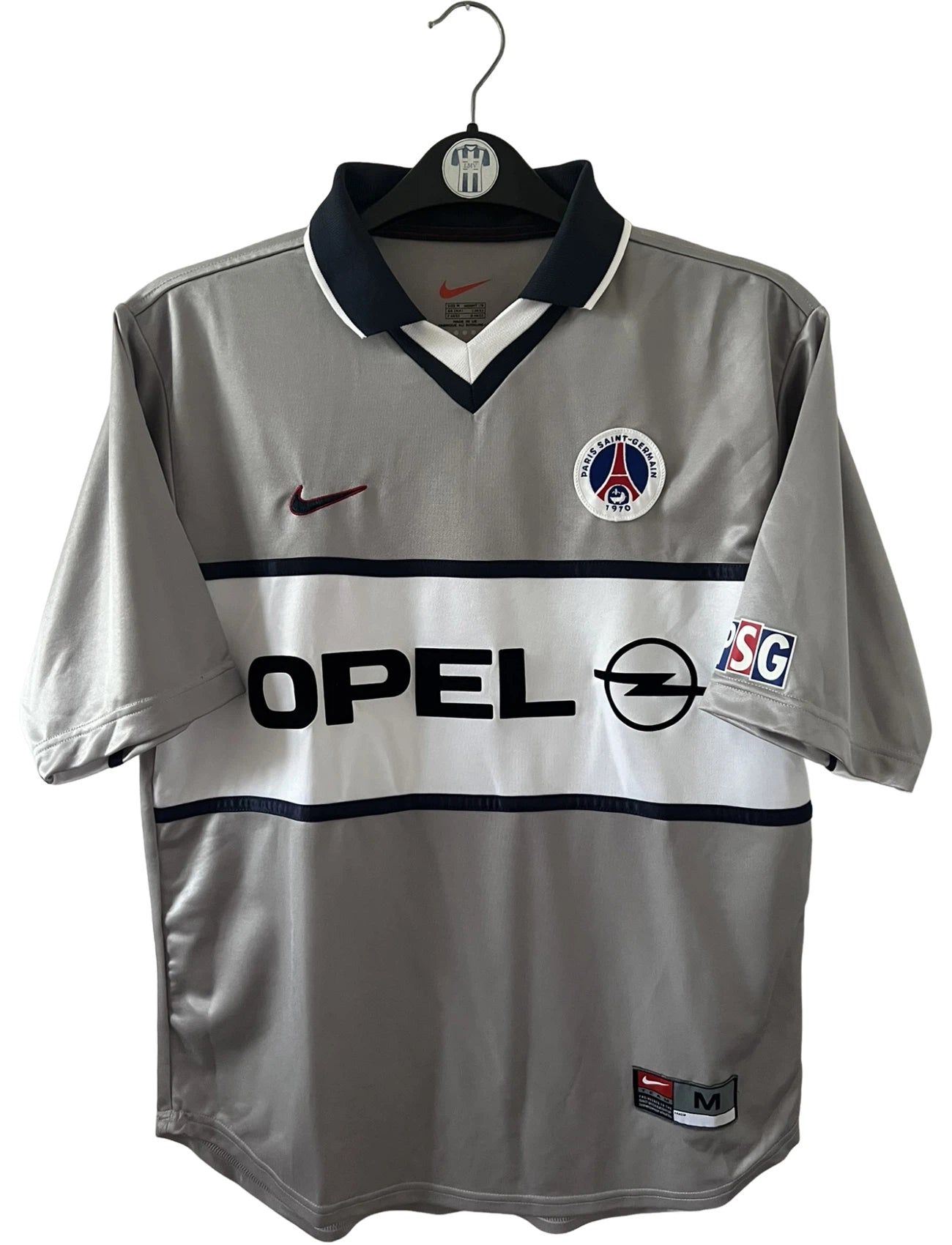 Maillot de foot vintage extérieur gris du PSG de la saison 2000/2001. On peut retrouver l'équipementier Nike et le sponsor Opel. Il s'agit d'un maillot authentique d'époque.