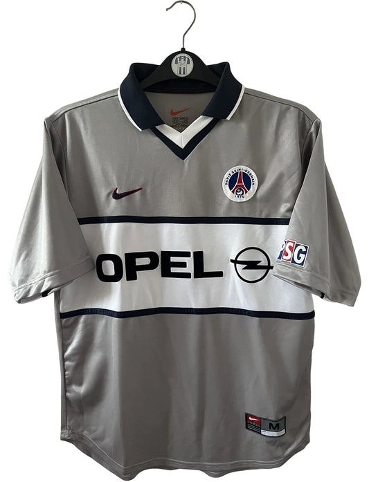 Maillot de foot vintage extérieur gris du PSG de la saison 2000/2001. On peut retrouver l'équipementier Nike et le sponsor Opel. Il s'agit d'un maillot authentique d'époque.
