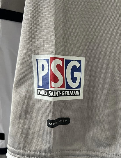 Maillot de foot vintage extérieur gris du PSG de la saison 2000/2001. On peut retrouver l'équipementier Nike et le sponsor Opel. Il s'agit d'un maillot authentique d'époque.