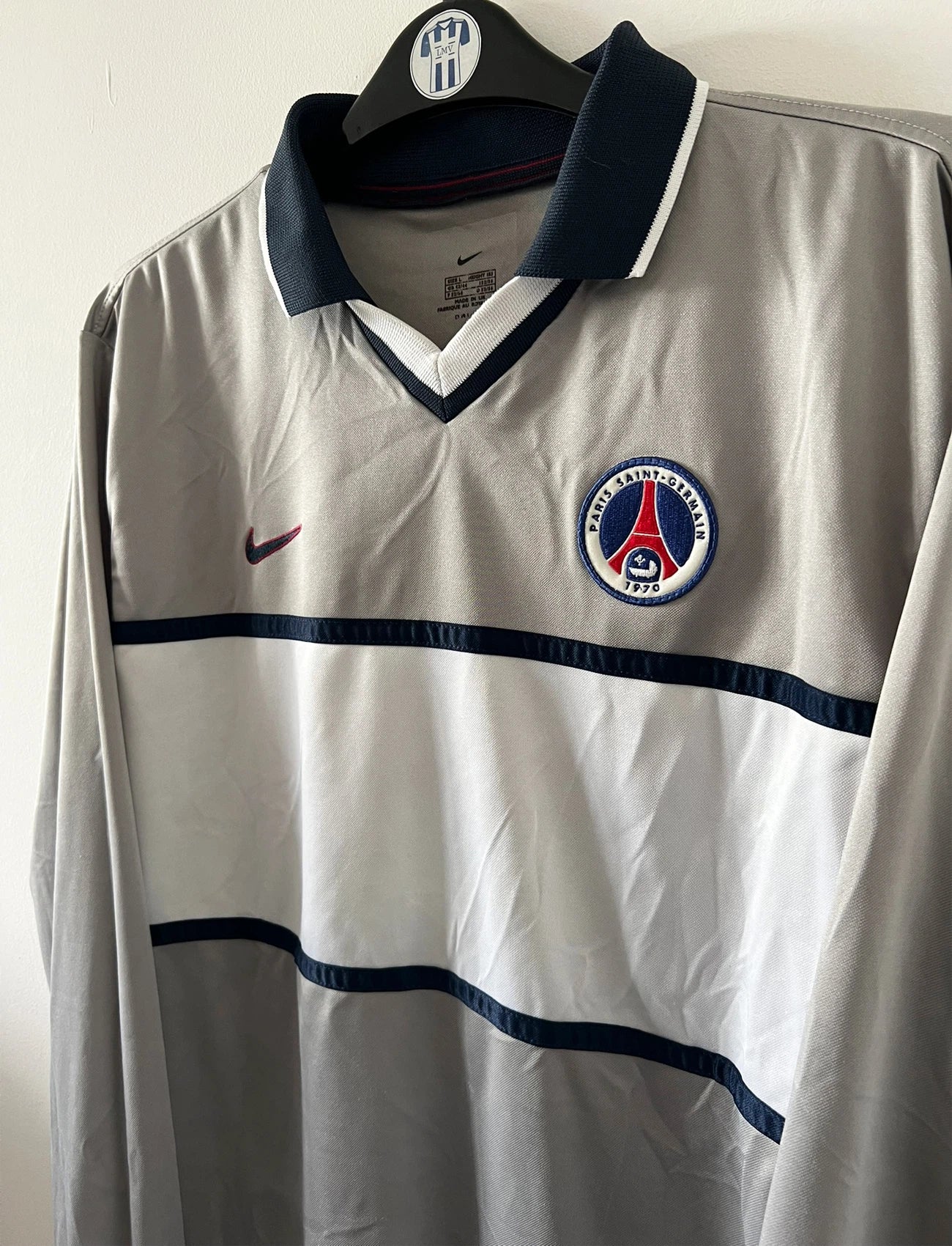 Maillot de foot vintage extérieur gris et blanc du PSG saison 2000/2001. On peut retrouver l'équipementier Nike. Il s'agit d'un maillot authentique d'époque issu du stock pro.