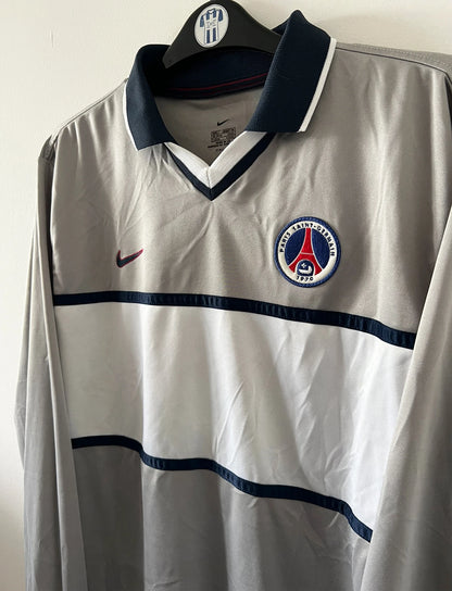 Maillot de foot vintage extérieur gris et blanc du PSG saison 2000/2001. On peut retrouver l'équipementier Nike. Il s'agit d'un maillot authentique d'époque issu du stock pro.