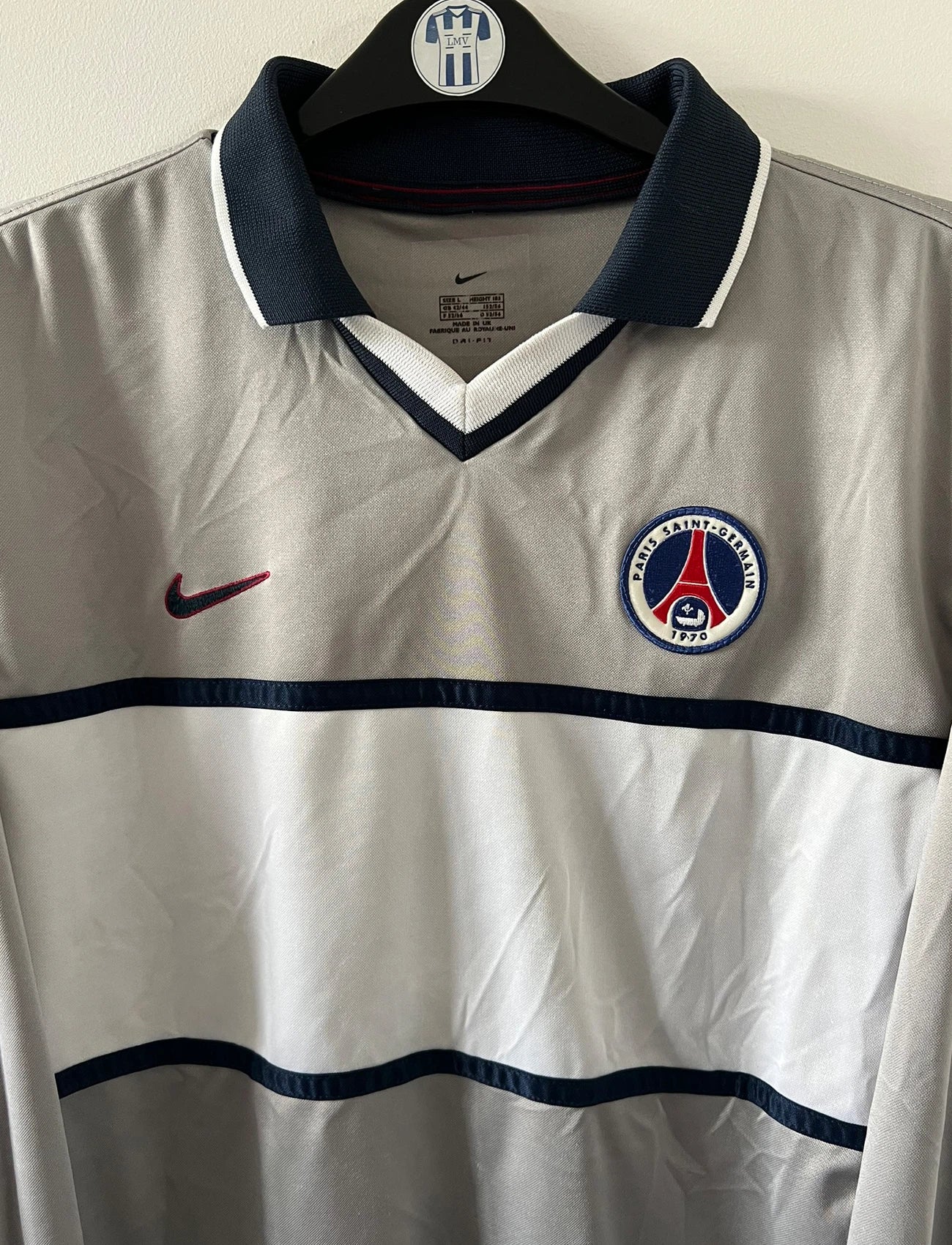 Maillot de foot vintage extérieur gris et blanc du PSG saison 2000/2001. On peut retrouver l'équipementier Nike. Il s'agit d'un maillot authentique d'époque issu du stock pro.
