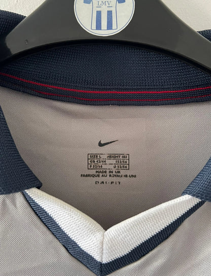 Maillot de foot vintage extérieur gris et blanc du PSG saison 2000/2001. On peut retrouver l'équipementier Nike. Il s'agit d'un maillot authentique d'époque issu du stock pro.