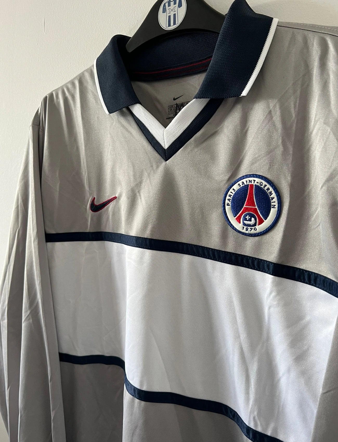 Maillot de foot vintage extérieur gris et blanc du PSG saison 2000/2001. On peut retrouver l'équipementier Nike. Il s'agit d'un maillot authentique d'époque issu du stock pro.