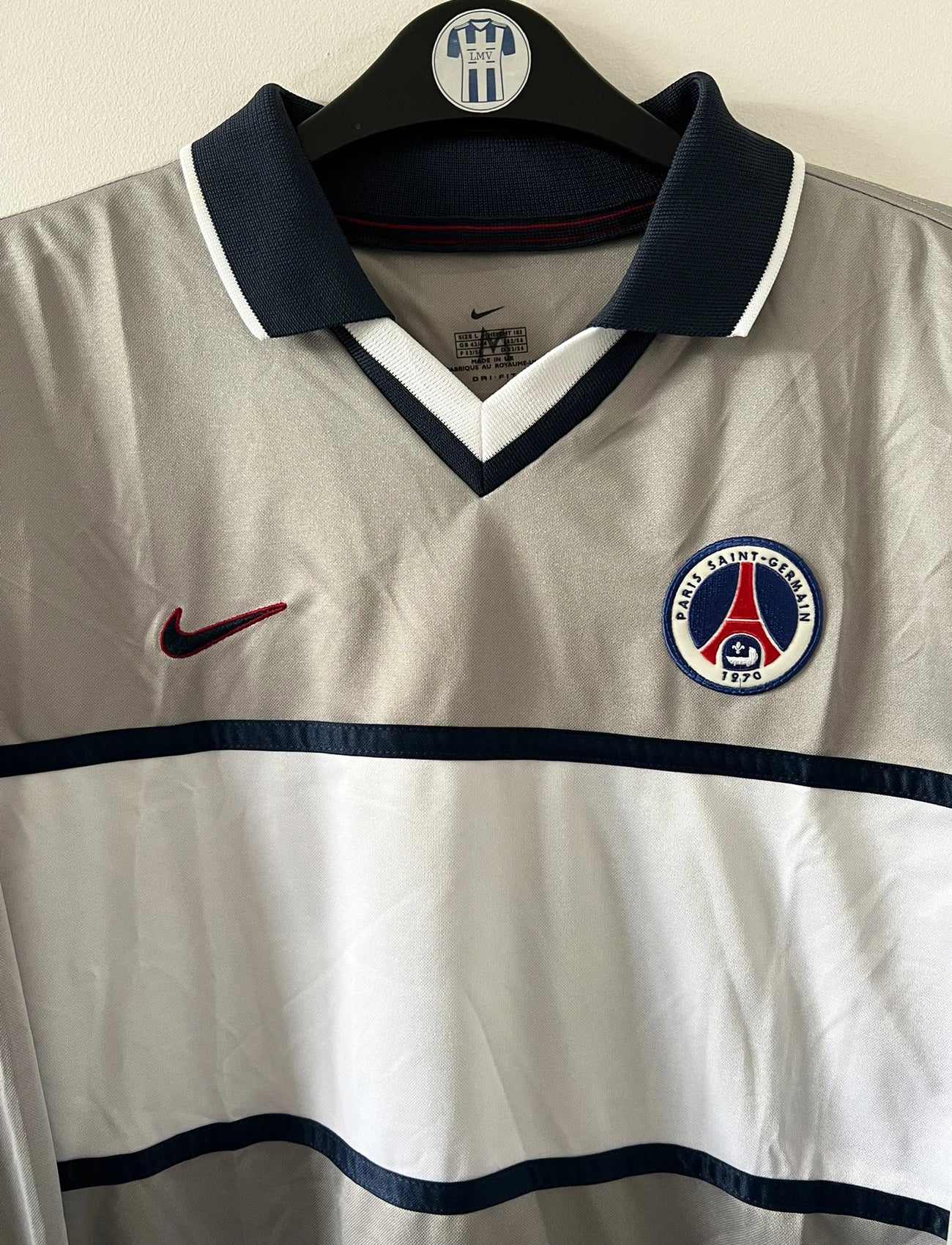 Maillot de foot vintage extérieur gris et blanc du PSG saison 2000/2001. On peut retrouver l'équipementier Nike. Il s'agit d'un maillot authentique d'époque issu du stock pro.