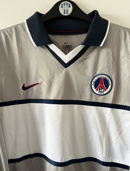 Maillot de foot vintage extérieur gris et blanc du PSG saison 2000/2001. On peut retrouver l'équipementier Nike. Il s'agit d'un maillot authentique d'époque issu du stock pro.
