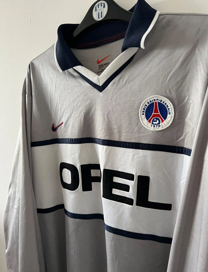 Maillot de foot vintage extérieur gris et blanc du PSG saison 2000/2001. On peut retrouver l'équipementier Nike et le sponsor Opel. Il s'agit d'un maillot authentique d'époque issu du stock pro.
