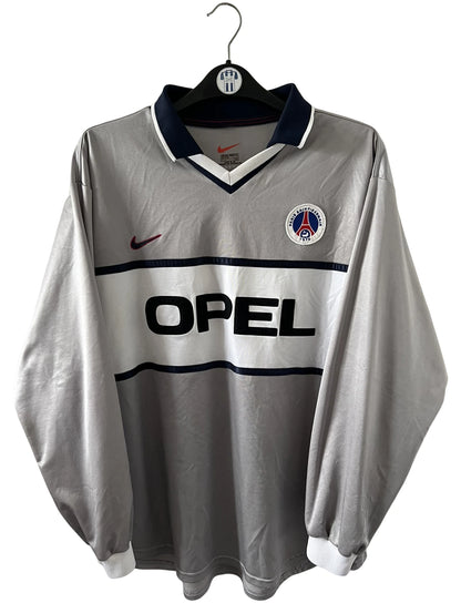 Maillot de foot vintage extérieur gris et blanc du PSG saison 2000/2001. On peut retrouver l'équipementier Nike et le sponsor Opel. Il s'agit d'un maillot authentique d'époque issu du stock pro.