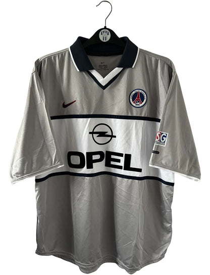 Maillot de foot vintage extérieur gris du PSG de la saison 2000/2001. On peut retrouver l'équipementier Nike et le sponsor Opel. Il s'agit d'un maillot authentique d'époque.