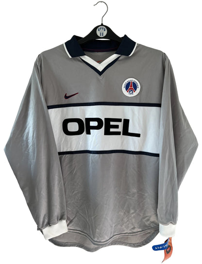 Maillot de foot vintage extérieur gris du PSG de la saison 2000/2001. On peut retrouver l'équipementier Nike et le sponsor Opel. Il s'agit d'un maillot authentique d'époque issu du stock pro du club.