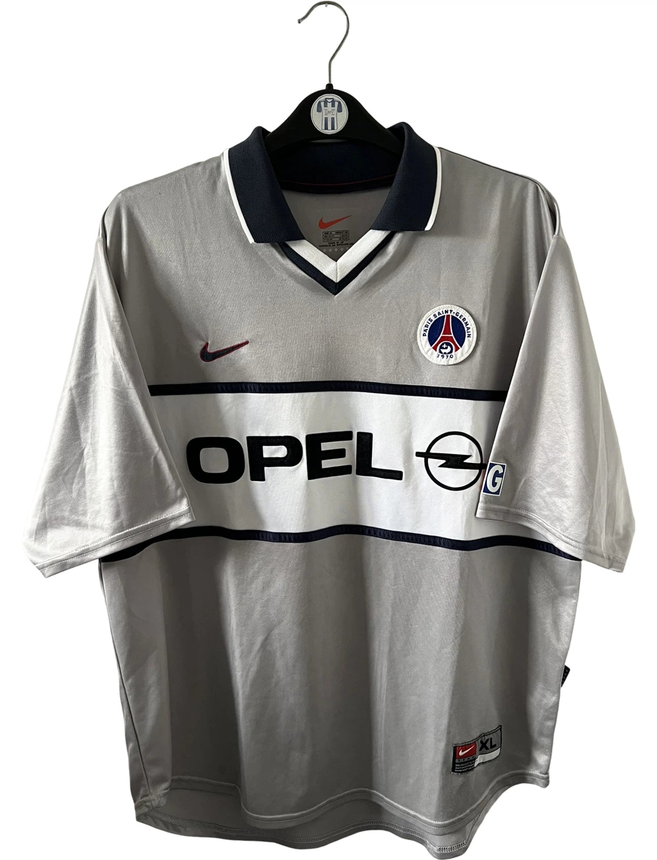 Maillot de foot vintage extérieur gris du PSG 2001/2002. On peut retrouver l'équipementier Nike et le sponsor Opel. Il s'agit d'un maillot authentique d'époque.
