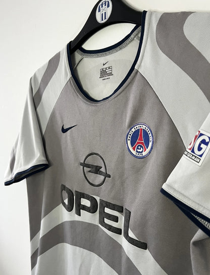 Maillot de foot vintage extérieur gris du PSG de la saison 2001/2002. On peut retrouver l'équipementier Nike et le sponsor Opel. Il s'agit d'un maillot authentique d'époque