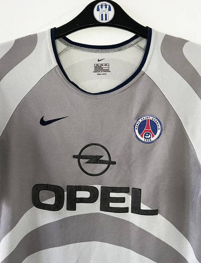 Maillot de foot vintage extérieur gris du PSG de la saison 2001/2002. On peut retrouver l'équipementier Nike et le sponsor Opel. Il s'agit d'un maillot authentique d'époque