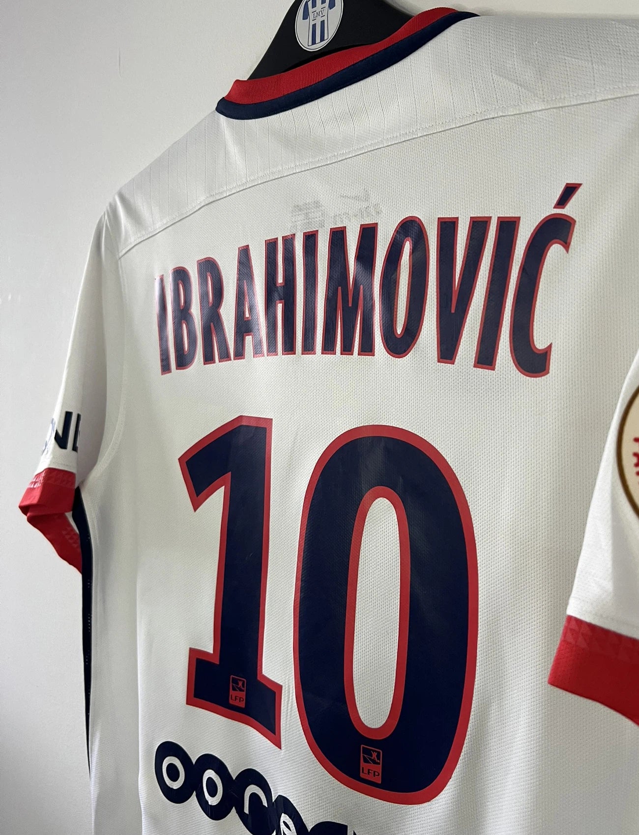 Maillot de foot vintage extérieur blanc du PSG de la saison 2015-2016. On peut retrouver l'équipementier nike et le sponsor fly emirates. Le maillot est floqué du numéro 10 Ibrahimovic. Il s'agit d'un maillot authentique d'époque comportant les numéros 88840899-106