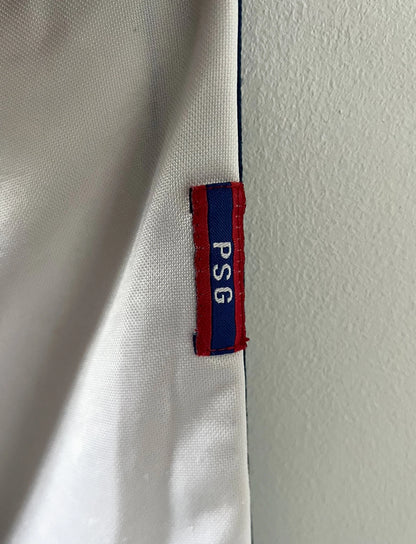 Maillot extérieur PSG blanc et rouge de la saison 1998/1999. On peut retrouver l'équipementier Nike et le sponsor Opel. Il s'agit d'un maillot authentique d'époque.