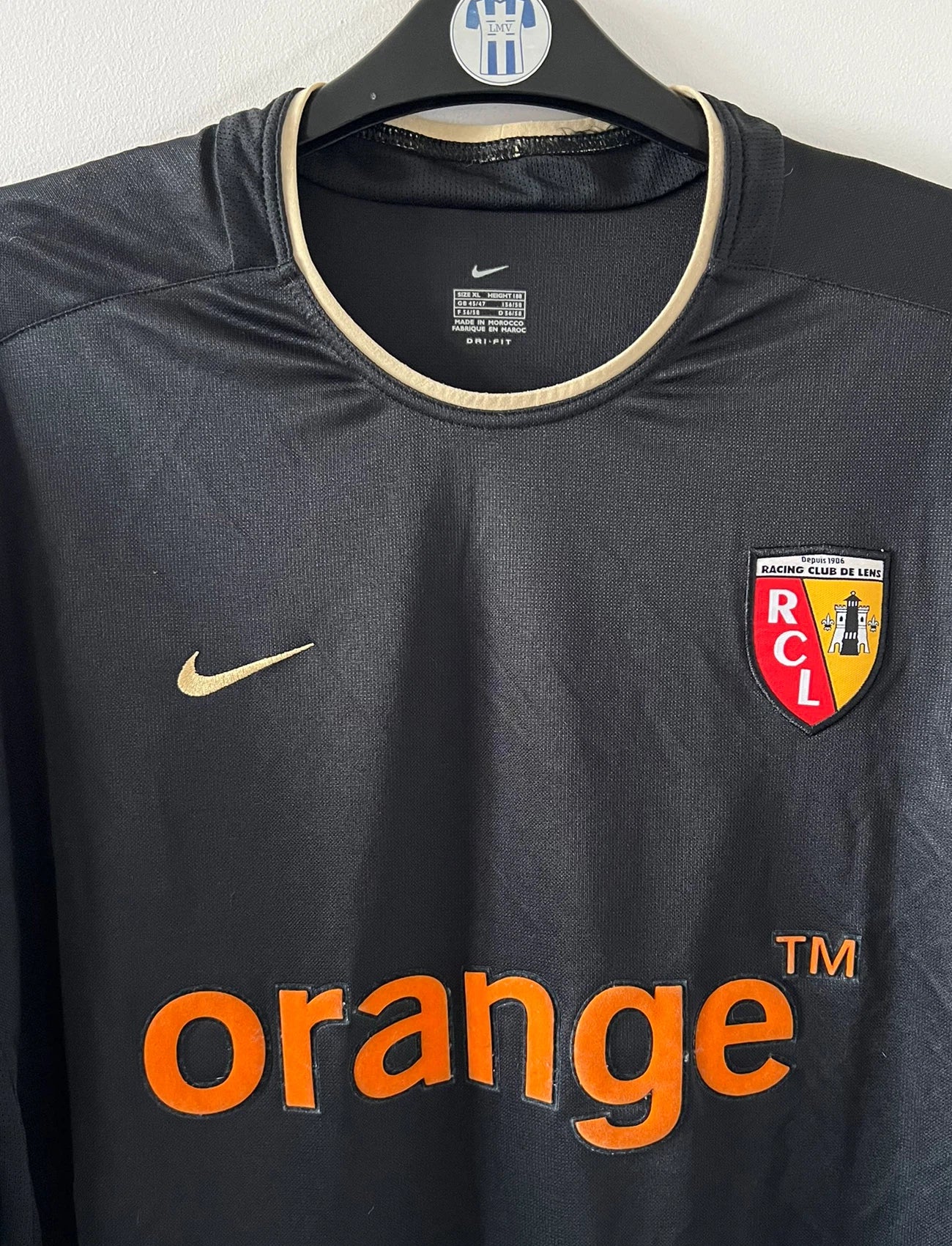 Maillot de foot vintage extérieur noir du RC Lens 2002/2003. On peut retrouver l'équipementier Nike et le sponsor Orange. Il s'agit d'un maillot authentique d'époque.