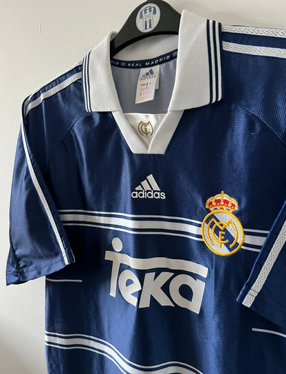 Maillot de foot vintage extérieur bleu du real madrid 1998/1999. On peut retrouver l'équipementier Adidas et le sponsor Teka. Il s'agit d'un maillot authentique d'époque.