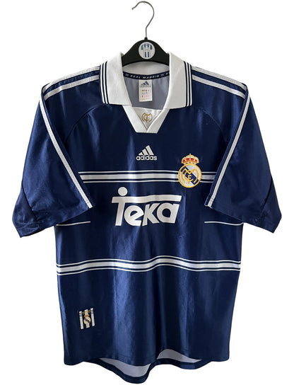 Maillot de foot vintage extérieur bleu du real madrid 1998/1999. On peut retrouver l'équipementier Adidas et le sponsor Teka. Il s'agit d'un maillot authentique d'époque.