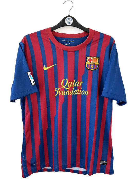 Maillot de foot vintage du FC Barcelone de la saison 2011/2012. Le maillot est de couleur rouge et bleu. On peut retrouver l'équipementier nike et le sponsor qatar foundation. Il s'agit d'un maillot authentique comportant les numéros 419877-488.