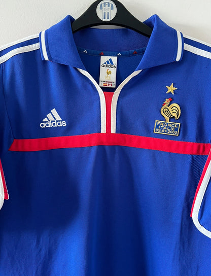 Maillot de foot vintage domicile bleu de l'Equipe de France 2000. On peut retrouver l'équipementier Adidas. Le maillot est floqué du numéro 10 Zinedine Zidane. Il s'agit d'un maillot authentique d'époque comportant la mention France-Italie 02-07-2000.